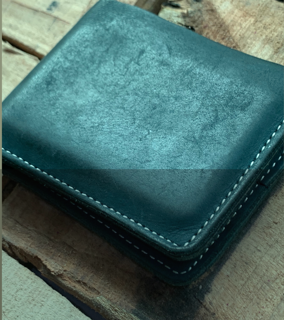 Blue leather wallet on a wooden surface with 'Ravera's Grand Opening Sale' text.